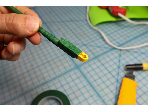 Continue to wrap the floral tape around the LEGO Beam to secure it.