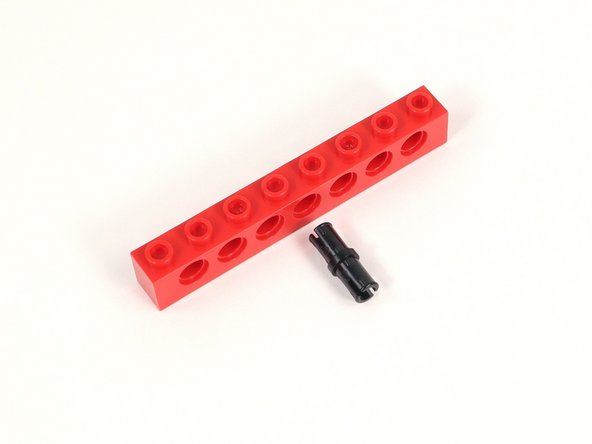 Add a black pin to the center hole of a 1x8 brick with holes.