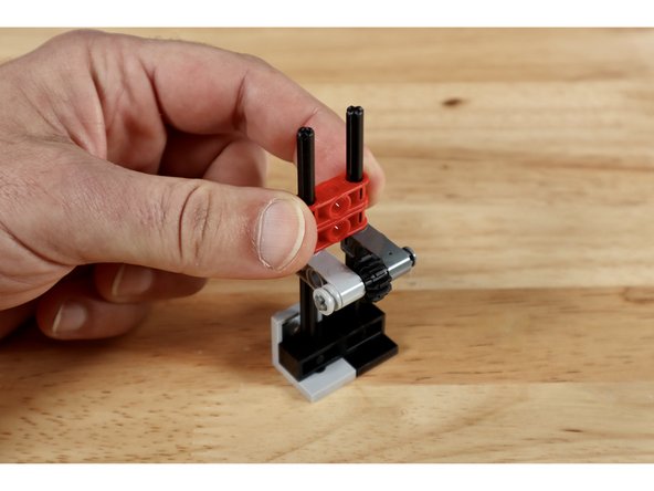 Now slide 2 of the (1x3) cross blocks with two axle holes down on top of those same two long vertically oriented axles until they touch the cross block below.