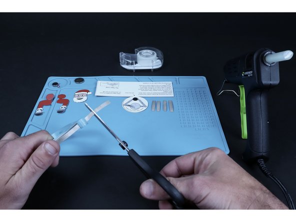 Use the circuit diagram on the back of the project to help you measure and cut the number of  pieces of conductive Maker Tape required for the project you chose. Rudolph will require 8 total pieces while Santa will require only 5 (this includes 1 piece for a tape loop).