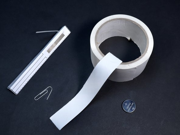 Gather your non-conductive tape, a single paperclip and your CR2032 battery. Prepare one length of Gaffer's or Duct Tape by tearing or cutting it in half the long way.  Prepare the paperclip by bending one end outward to yield the shape shown at left.