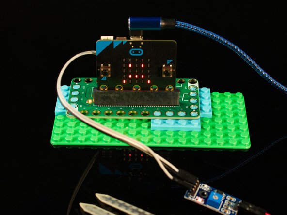 We're going to load the following code for our Moisture Sensor Alarm program:  https://makecode.microbit.org/_RXkYgP7L6...