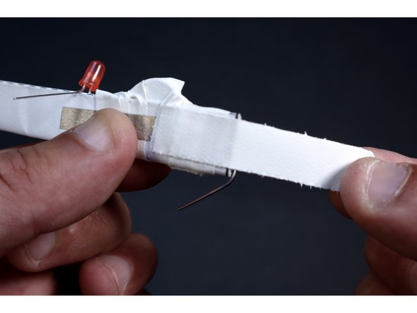 With another small piece of gaff/duct tape, wrap ACROSS the paperclip. This is an important area to strengthen because this paperclip is part of the launching apparatus and will be under rubber band tension while in the process of being flung.