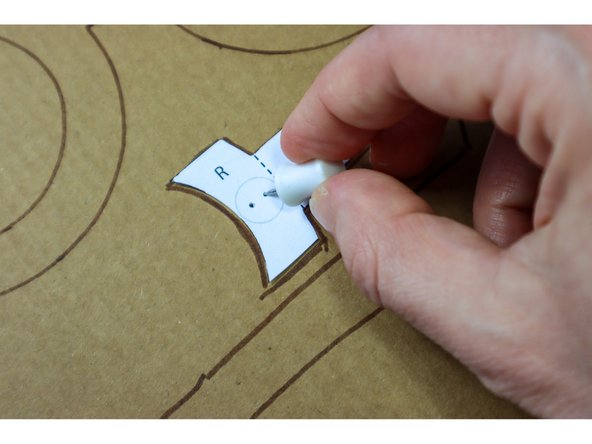 Use a push pin or awl to make holes through the cardboard as shown on the template, where the LEDs will go.