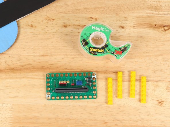 Place 1x6 LEGO plates into the holes of the Bit Board. Use tape to temporarily secure them in place.
