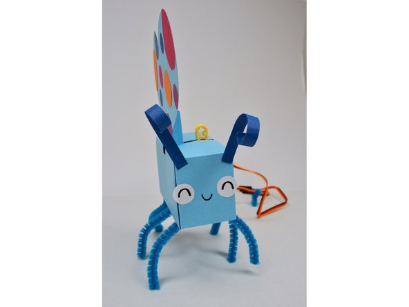 Slide the wing holder through the slot in the body and onto the LEGO axle mounts.