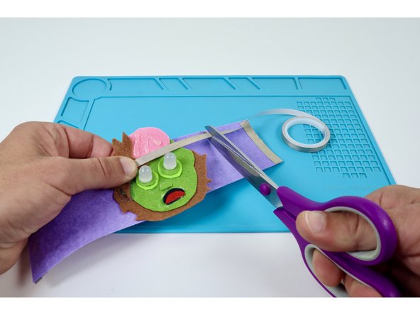 Measure and cut two Maker Tape paths that can reach from the furthest LED out to a point just past the edge of the felt embellishment.