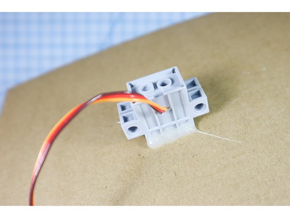 Hot glue the motor in place.