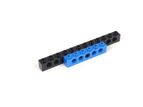Connect the black pin through the middle hole of a 1x6 brick with holes.
