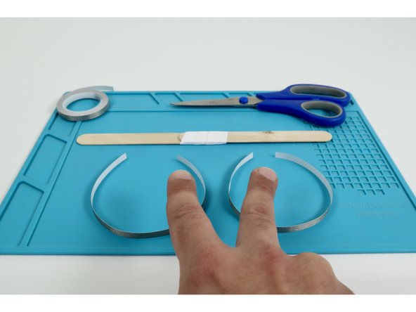 Measure and cut two separate Maker Tape pieces that are approximately the length of the wand handle you created.