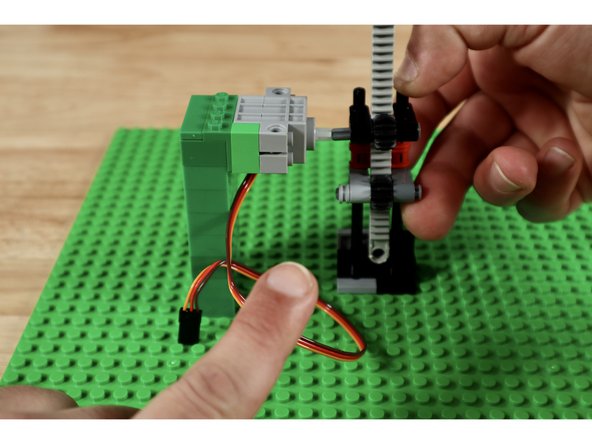 The servo axle will need to connect to the free end of the topmost axle during final assembly. You will need to adjust its height. To do this, pick any spot on the base plate and connect the servo tower. Then connect the gear rack right next to it. This will help you gauge the height of the two axles that need to be level with one another.