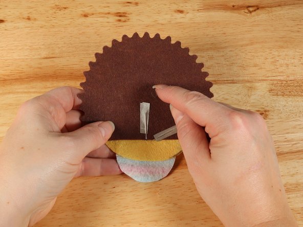 Make a loop of tape (sticky side out) using a short piece of Maker Tape, and stick it atop the end of the path coming from the short (Negative) LED leg.