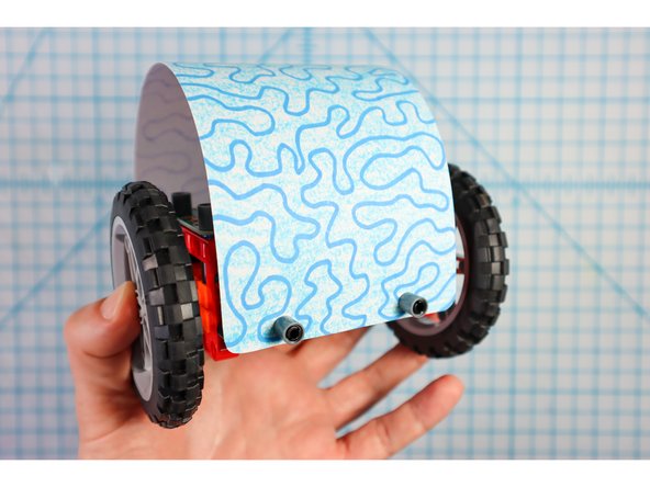 Wrap the paper over the body and use two more pin/beam sets to secure the front as shown.