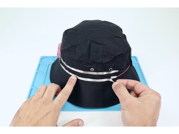 As shown in photos 2 and 3 measure/cut/ peel/stick a Maker Tape path that connects the upper negative path of the LED portion of your circuit to the black negative pad of the battery pack. Then connect the remaining lower path from the LEDs to the red positive pad of the battery pack.