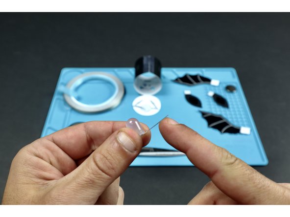 Prepare the LED by bending the legs so that the LED bulb can lay flat.  Then bend them outward in opposite directions so there's enough space between them for a battery to sit without touching.