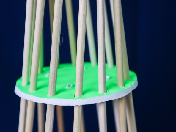 Place the circle over the dowels one at a time. It's ok to bend them a little to get them into place.