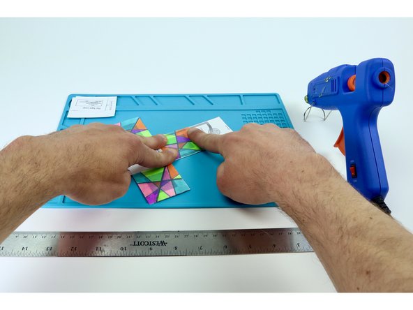 After each of the 4 colored panels have been added, use a ruler as shown in photo 3 to help you fold the sides in preparation for final assembly.  It is easier to do this now without having added the circuitry.