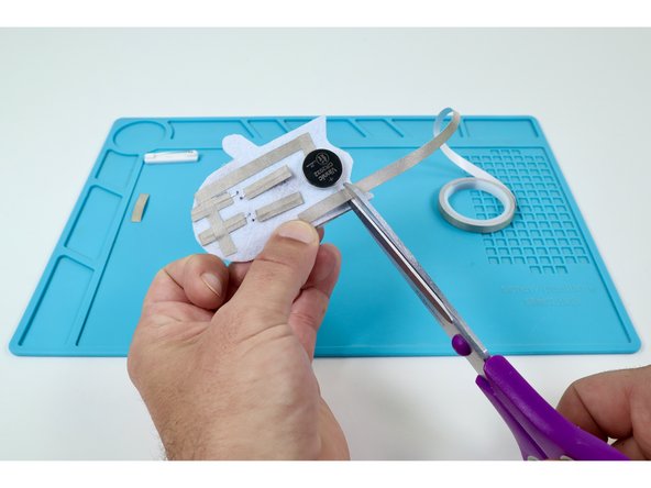 Measure and cut three final pieces of Maker Tape as shown in the photos at left. These pieces will be used to create the path leading from the Long LED Legs back to the top of the battery.