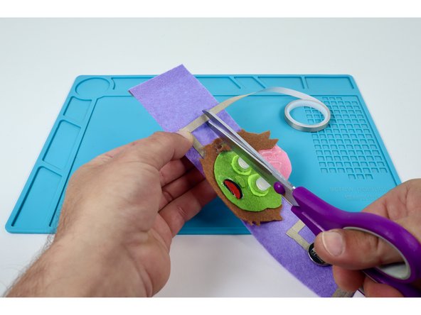 Measure, cut, peel, and stick  the same two Maker Tape paths that began the extension of the Short LED Leg side of the bracelet.