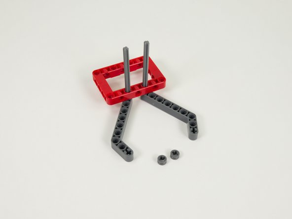 Slide two gray half bushings onto the tops of the axles and press down against the red frame.