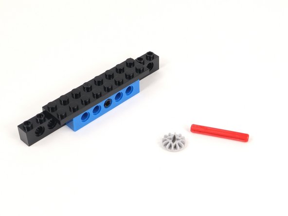 Connect the small gray gear to the end of the 4 stud long red axle.