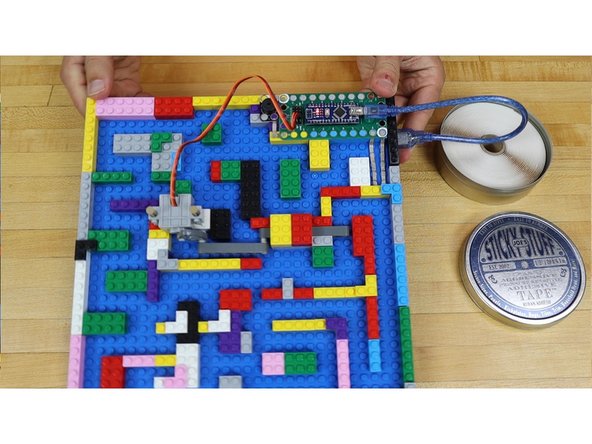 Use double-sided tape to attach a 5V USB &quot;power bank&quot; style battery to the back of the LEGO baseplate.