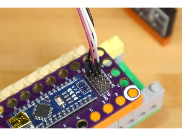 Typically the Robotics Board is use with conductive tape to build circuits directly on top of LEGOs, but since we're just using two servos and a distance sensor, we can plug those directly into the header pins on the board.