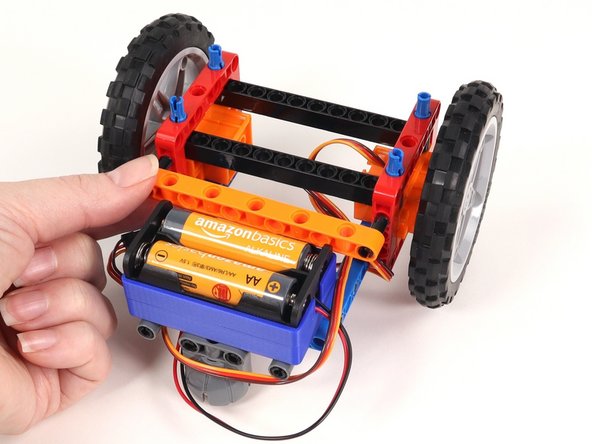 Add the orange beam to the back of the Rover. The black pins should go in the top holes of the red frames.