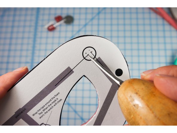 Use an awl, push pin, safety pin, or other pointy tool to make holes for the LED legs to stick through.