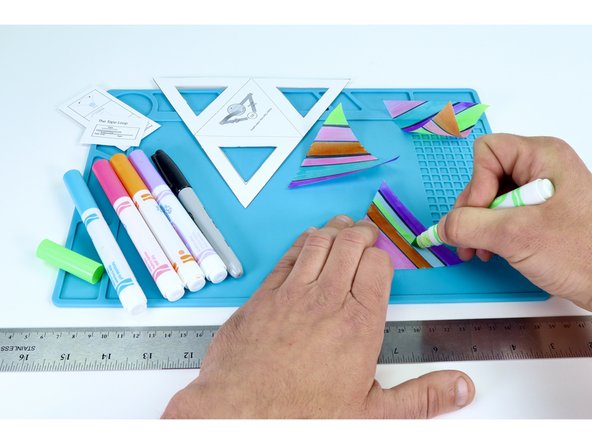 Use a black marker to create designs on your tracing paper triangles that break the triangles up into sections. Then color the sections in with markers as you wish.  Anything goes!