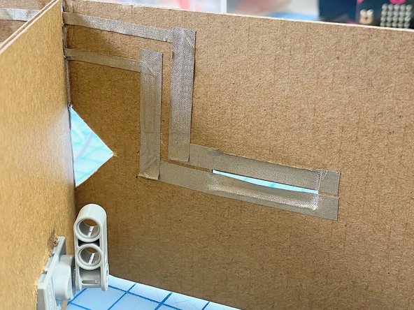 We ran the Maker Tape from each of the two pieces, around the box, and down to where the LEGO connections to the Bit Board were located. One is connected to pin 0 and the other is connected to Ground.