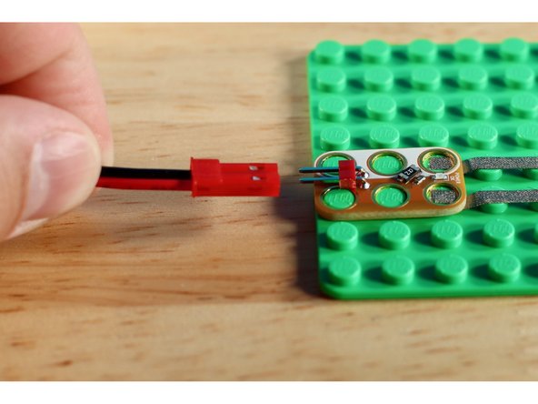 The battery pack should be inserted as shown in our pictures. The flat side of the red connector should face downwards, and the two silver tabs should face upwards.