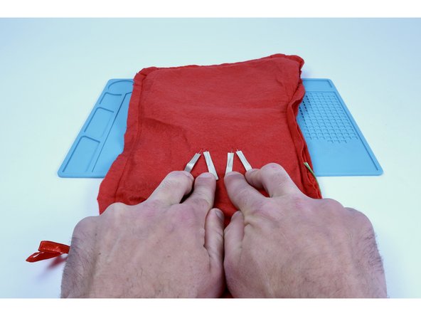 After the 4 LED legs have been sandwiched, bend them flat against the stocking fabric and toward the opening of the stocking. Eventually, the project will need to be turned right-side-out and the circuitry can often get jostled out of working condition. Having the circuit near the opening makes it easier to adjust afterward.