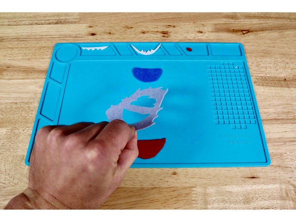 Because the face and mouth are designed to be BEHIND the rest of the head, you will first need to flip these pieces from this original orientation to the opposite side before gluing them into place.