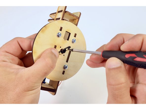 Turn each of these two screws so that their tips just barely poke out the back of the servo horn (this will help you keep this part aligned while screwing it to the wooden assembly).