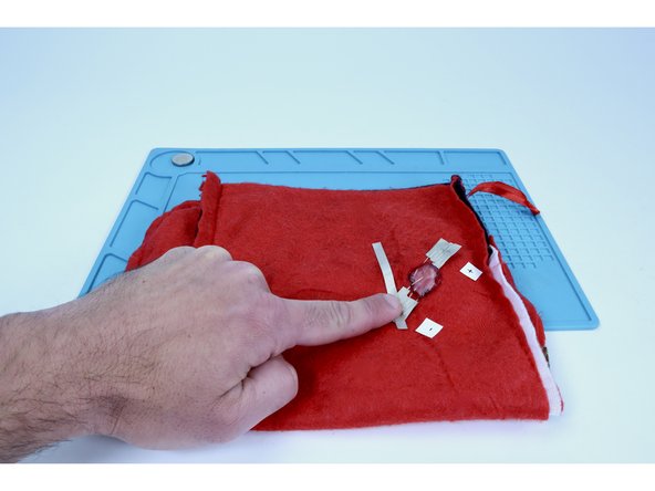 Cut a slightly longer piece of Maker Tape than you've cut so far for this project and press it atop the Maker Tape pad for the negative (short) legs while guiding it at an angle generally toward the stocking opening.