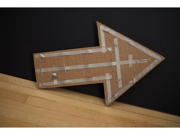 Use a tape loop at attach the battery's negative side to the tape on the arrow.