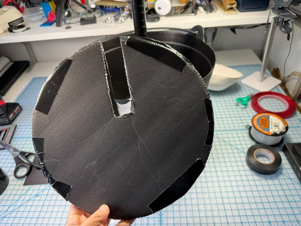 Make a platform for the candy to sit on with two layers of foam core and a slit for the pipe to go thru. Then, cover the slit with black paper so the candy doesn't fall down!