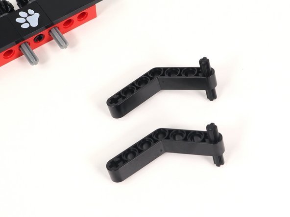 Insert a 3 stud long black axle into the plus-shaped hole at the end of a black bent beam. You will need two of these.