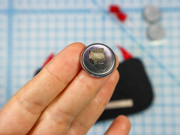 Make a loop of Maker Tape with the adhesive side out and place it on the negative side of the battery.