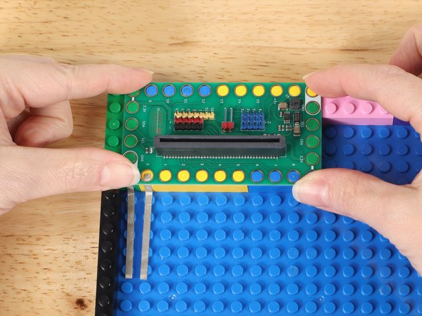 Press the Bit Board onto LEGO bricks over the Maker Tape.