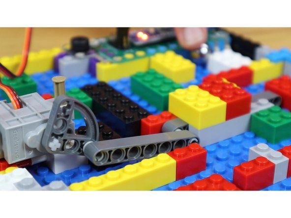 When the ball bearing touches both pieces of tape, the servo will rotate to open the gate and a musical countdown will begin.