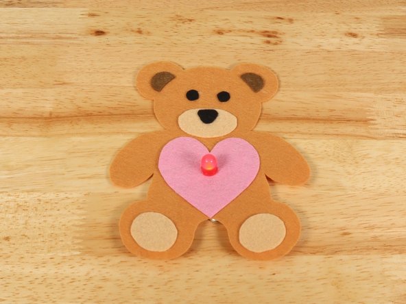 To make the Teddy Bear look like it is holding the heart, fold the paws inward and keep them in place with a small amount of hot glue.