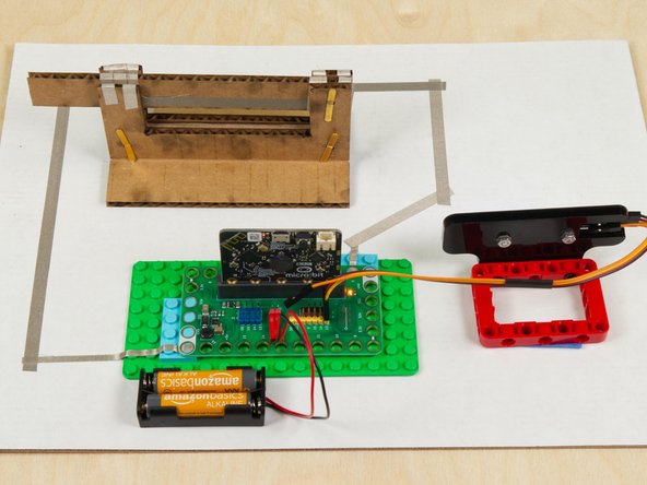 When connecting Crazy Circuits projects to paper circuits-style projects we usually stick everything down to a piece of scrap cardboard.