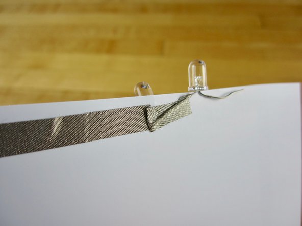 Tape down the short, negative, leg of your second LED.