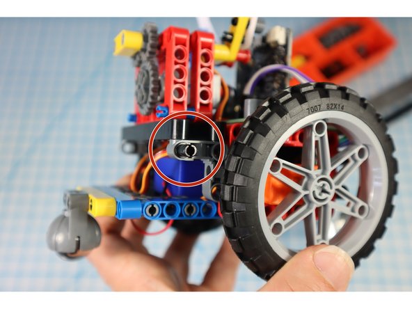 Add a pin to each of the gray supports on the back as shown.