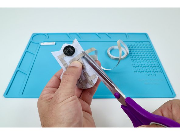 Measure and cut three final pieces of Maker Tape as shown in the photos at left. These pieces will be used to create the path leading from the Long LED Legs back to the top of the battery.