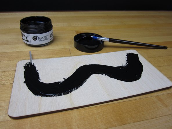 Starting on top of your tape, apply a long line of paint. Try to paint on evenly.