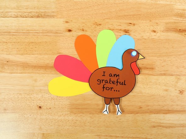 Make a tape loop of clear tape and attach the feathers to the back of the turkey.