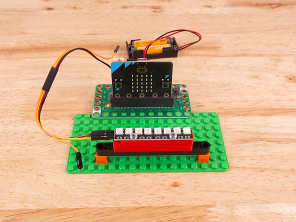 To mount the NeoPixel Stick in place we used our NeoPixel Beam Holder with a long Technic Beam and two 1x1 LEGO bricks.